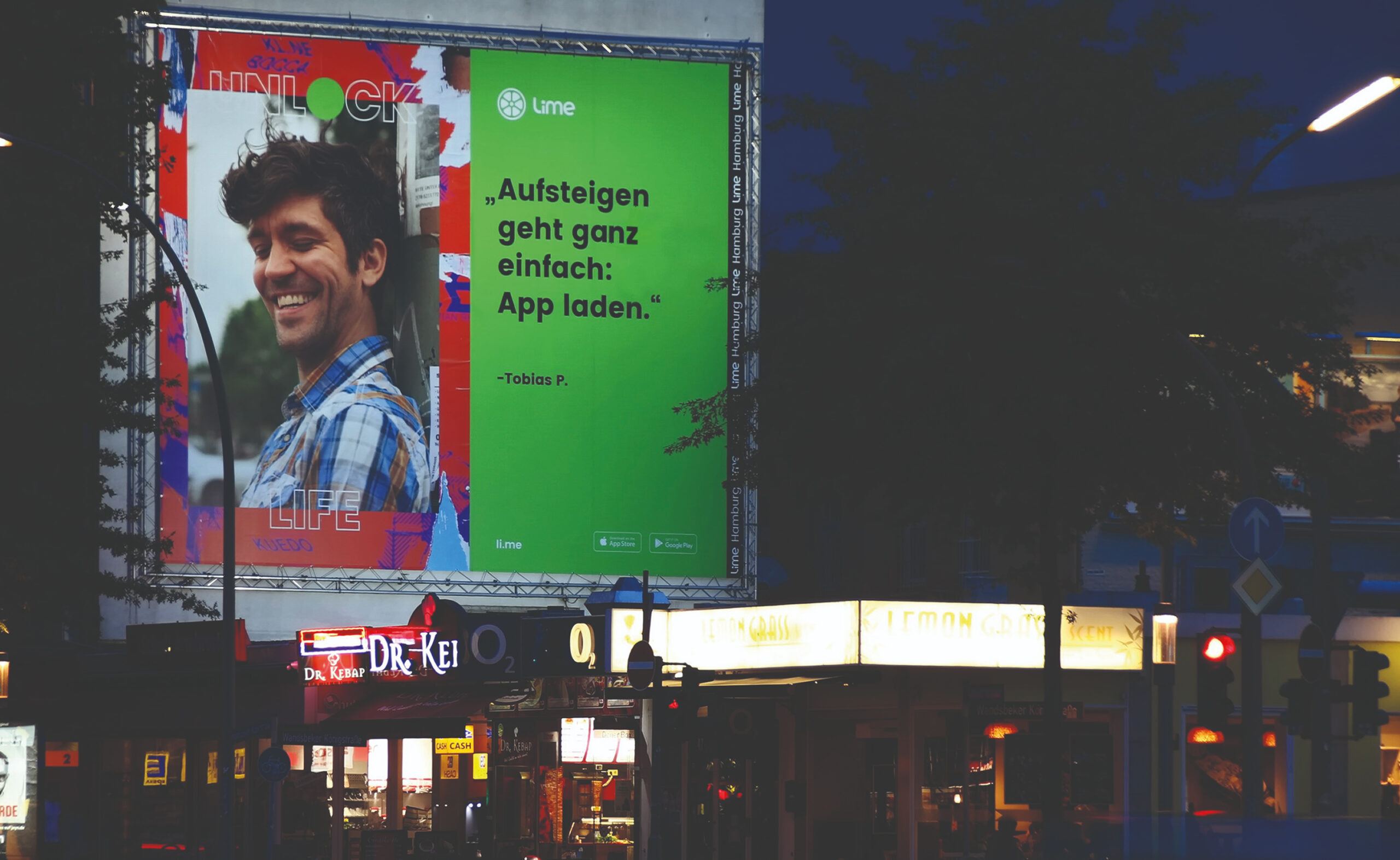 Unlock Life poster displayed on a large building-mounted billboard at night