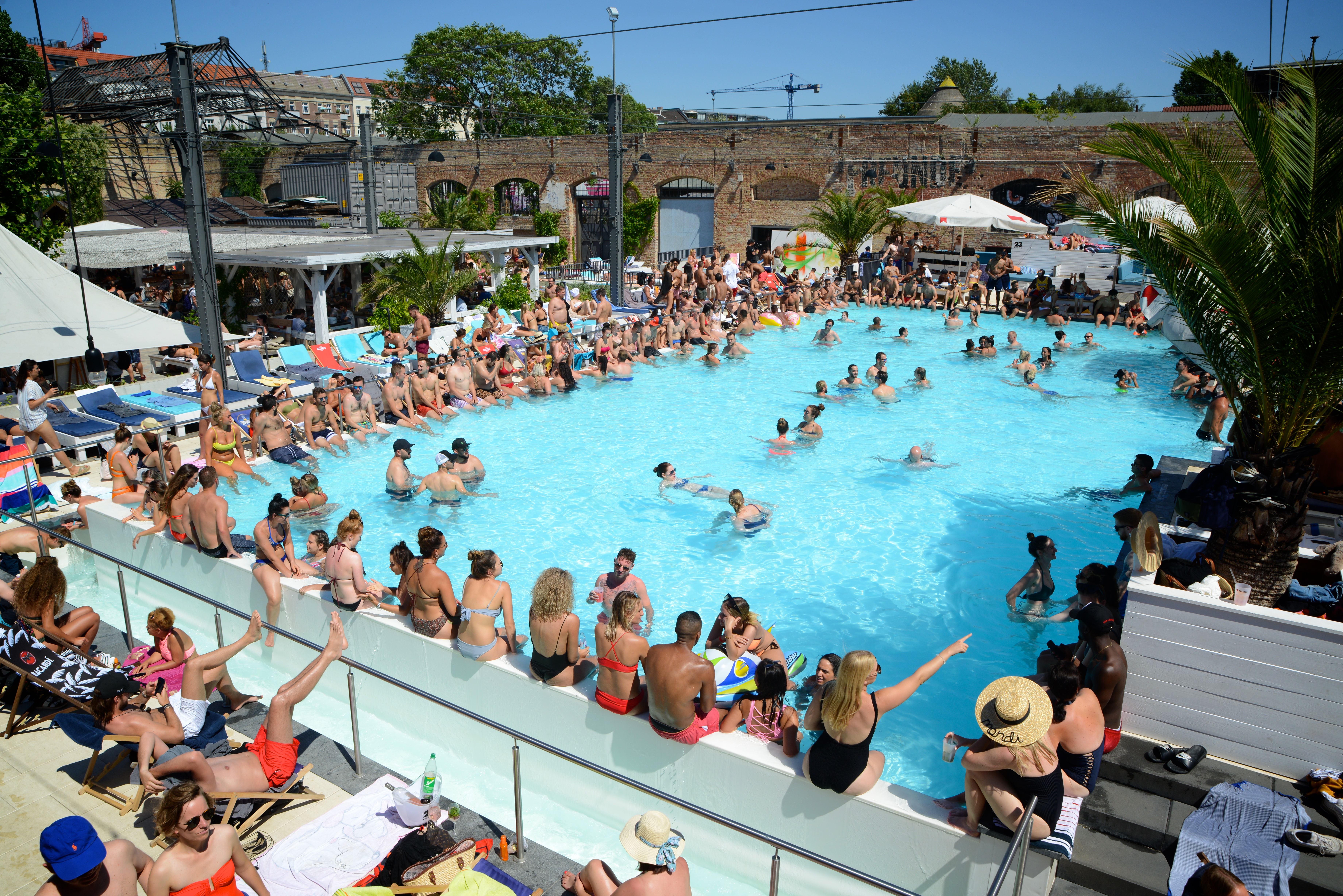 Crowd of people at a rooftop pool party for the Lime First Ride event