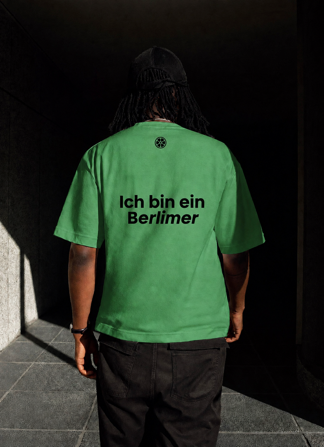 A guest wearing a green 'Ich bin ein Berlimer' t-shirt