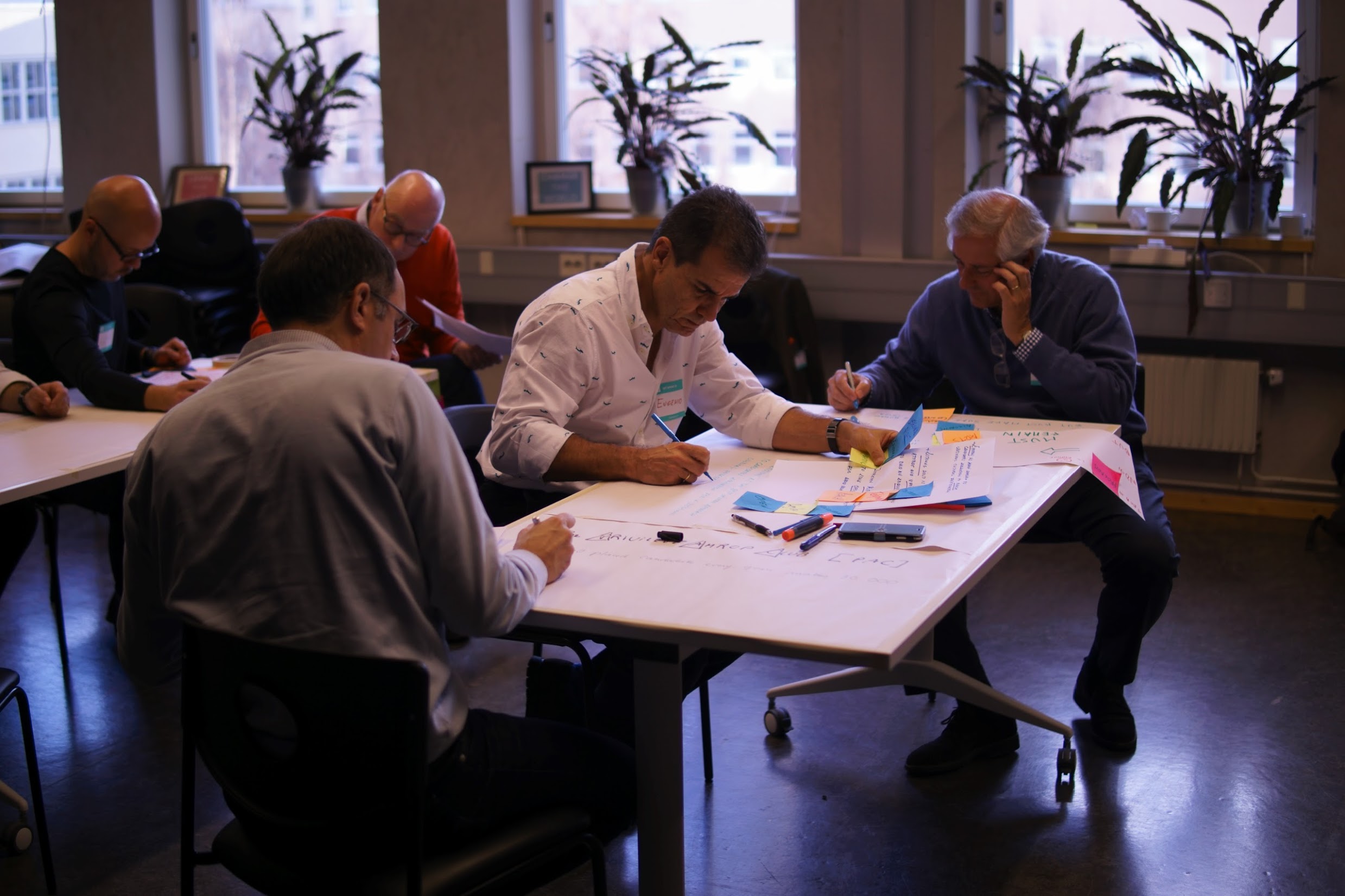 Amrop team members working on ideas at tables