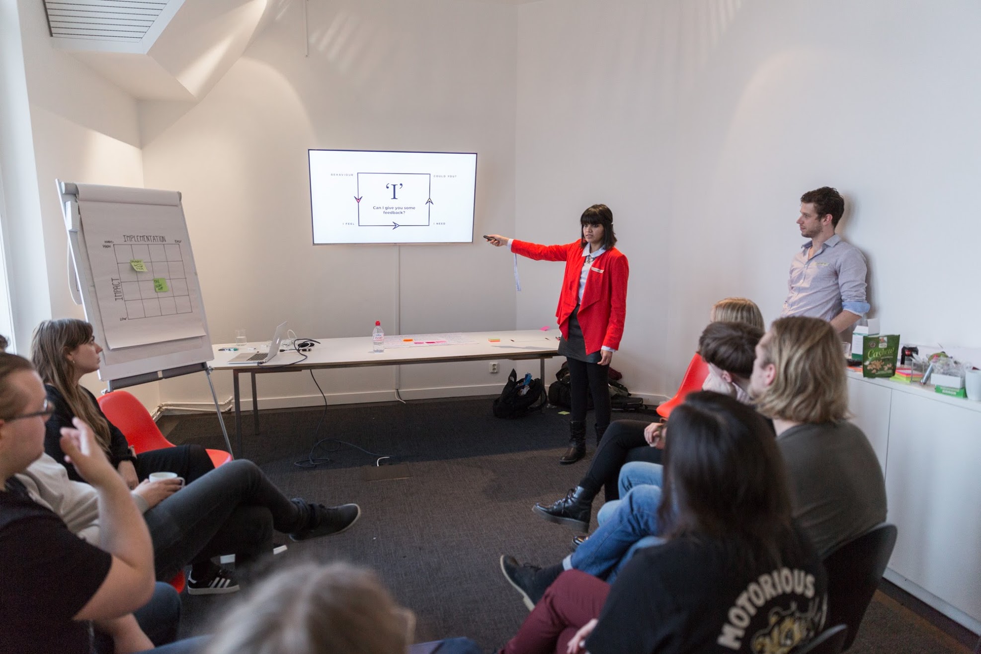 Workshop participants sketching on large sheets of paper around a table